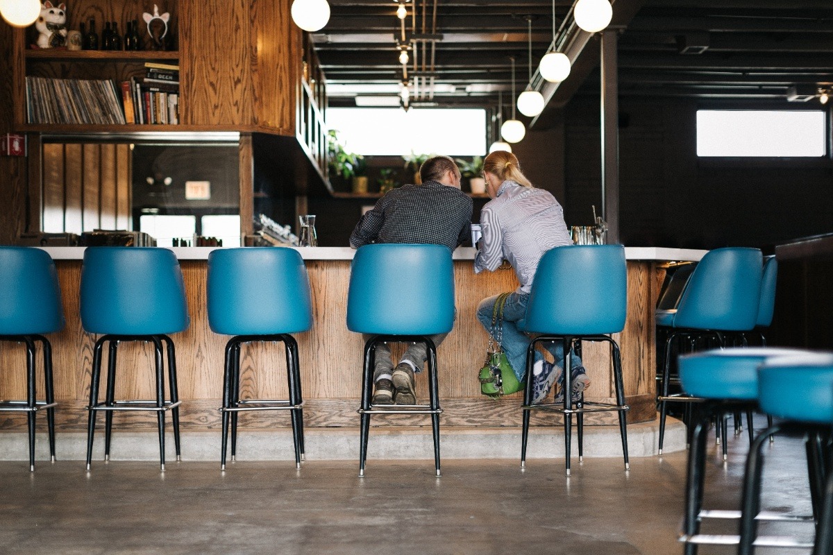 Two people sitting at the bar inside Sleeping Village